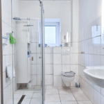 Badezimmer mit ebenerdiger Dusche, WC und Fußbodenheizung